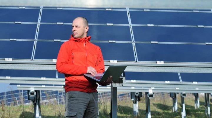 Usługi O&M dla farm fotowoltaicznych obejmują wiele działań. Na zdjęciu pracownik firmy O&M przeprowadza analizę na farmie fotowoltaicznej.